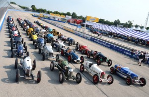 36 vintage Indy cars are lined up on the front straightaway for the 21st annual Harry Miller Club Vintage Indy Car Meet. 50 cars were on hand for the signature event on the vintage oval racing calendar. [Photo by Russ Lake]